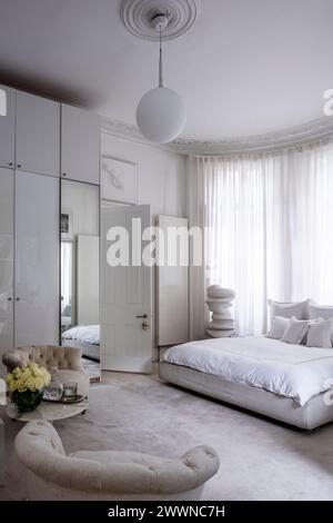 Miroir pleine longueur dans la chambre blanche avec sculpture d'art moderne dans l'appartement West London, Royaume-Uni Banque D'Images