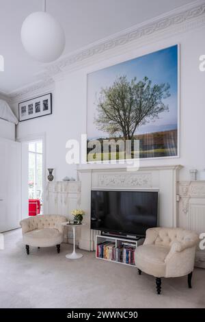 Paire de fauteuils avec TV et œuvres d'art dans l'appartement moderne West London, Royaume-Uni Banque D'Images