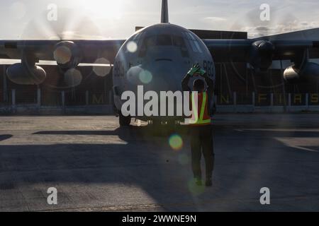 Tech. Le sergent Charles Garcia, membre de l'armée de l'air philippine du 522e escadron des opérations, du 520e groupe de la base aérienne, guide au sol un avion KC-130J Super Hercules à la base aérienne de Villamor, Pasay City, Philippines, le 13 février 2024. À la demande du gouvernement des Philippines, les Marines of III Marine Expeditionary Force des États-Unis soutiennent l'Agence des États-Unis pour le développement international dans la fourniture d'une aide humanitaire étrangère à la mission de secours en cas de catastrophe en cours à Mindanao. La présence avancée et la position prête des moyens du MEF III dans la région ont facilité des remontées rapides et efficaces Banque D'Images