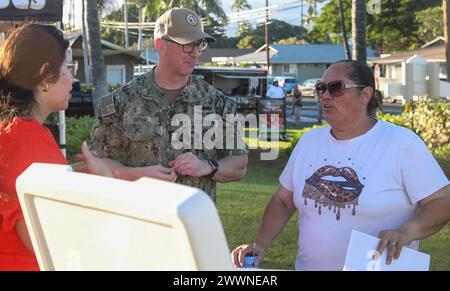 Jason Dunn, le chef principal des forces recrutées pour le commandant du Navy installations Command, qui supervise 70 bases navales à travers le monde, parle avec un résident d’Hawaï du programme de surveillance à long terme de l’eau potable de la Marine lors d’un marché nocturne à Ewa Beach, Hawaï, le 14 février 2024. La Marine organise un kiosque d'information mensuel à divers endroits pour informer le public sur le programme et sur la façon de lire les résultats de l'eau potable sur le site Web de la base conjointe Pearl Harbor-Hickam Safe Waters. Dunn est l'un des nombreux chefs de la Navy qui se sont rendus à Hawaï pour soutenir la Navy Closure Task Banque D'Images