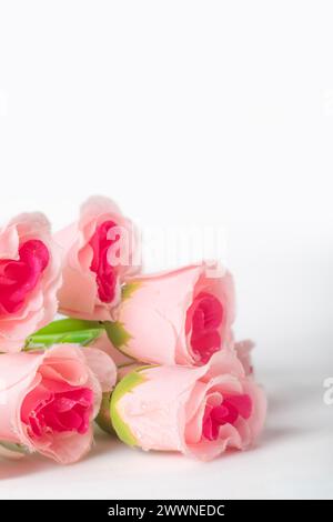 Bouquet de roses roses sur fond blanc avec espace de copie. Prise de vue verticale Banque D'Images