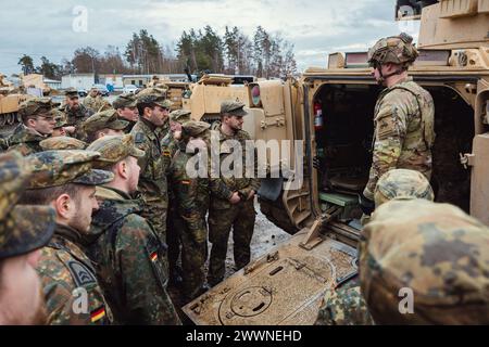 Les soldats allemands affectés à l'Unteroffizierschule des Heeres ont visité la zone d'entraînement de Grafenwoehr (GTA) du 7e Army Training Command (7ATC) et ont interagi avec les soldats de l'armée américaine affectés à la 1re division blindée à Grafenwoehr, Allemagne, le 22 février 2024. Les soldats américains présentaient les véhicules qu'ils utilisent et répondaient aux questions des étudiants allemands pendant la semaine du partenariat germano-américain. La semaine du partenariat germano-américain permet aux étudiants allemands d'améliorer leurs compétences linguistiques en anglais et de se familiariser avec les coutumes des soldats américains à GTA tout en construisant des relations plus solides Banque D'Images