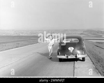 Vaction en Italie dans le 1951. Un homme à sa voiture pendant un voyage de vacances en voiture en Italie. Il s'est arrêté le long d'une route et a fait des vagues devant le photographe. Conard ref 1666 Banque D'Images