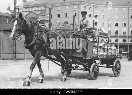 Dans les années 1930 Un cheval et calèche photos dans une rue de Stockholm 1936. Le chariot tiré par des chevaux a une charge de grandes bouteilles de lait. Banque D'Images