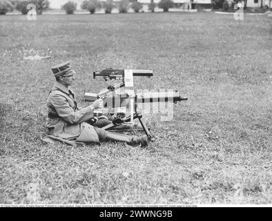 Mitrailleuse. Un militaire en uniforme lors d'un exercice de tir sur le terrain militaire de Rosersberg à Stockholm. La mitrailleuse est une arme à feu entièrement automatique à chargement automatique conçue pour un tir direct soutenu avec des cartouches de fusil. La mitrailleuse qu'il tire est un modèle M14-29, un Browning américain modèle 1917. La mitrailleuse derrière est un M/14 Schwarzlose. Banque D'Images