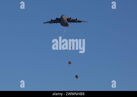 Des soldats de l'armée américaine du 3e bataillon, du 509e régiment d'infanterie parachutiste, de l'équipe de combat de la 2e brigade d'infanterie (aéroportée), de la 11e division aéroportée, descendent sur la zone de chute de Donnelly après avoir sauté d'un C-17 Globemaster III de l'US Air Force dans le cadre du joint Pacific multinational Readiness Center 24-02 à Donnelly Training Area, Alaska, le 8 février, 2024. Le JPMRC 24-02 dépend de partenaires conjoints, multicomposantes et multinationaux pour réussir, y compris les équipages aériens et terrestres de l’US Air Force, les Marines américains et les participants militaires internationaux de plus de cinq pays, un témoignage du réalisme et de l’authenticité Banque D'Images