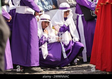 Antigua, Guatemala. 24 mars 2024. Les pénitents s’agenouillent en prière au début de la procession du dimanche des Rameaux la Reseña depuis la Parroquia San Sebastián la Merced marquant le début de la semaine Sainte, le 24 mars 2024 à Antigua, Guatemala. Les processions opulentes, les algèbres détaillées et les traditions séculaires attirent plus d'un million de personnes dans l'ancienne capitale. Crédit : Richard Ellis/Richard Ellis/Alamy Live News Banque D'Images