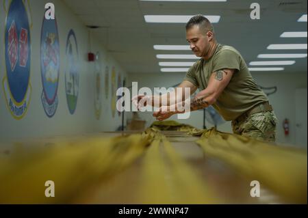 Marcus Kelley, un aviateur de 1re classe de l'US Air Force, technicien en équipement de vol de l'équipage, affecté au 23rd Expeditionary Bomb Squadron emballe un parachute B-52H Stratofortress après une mission de routine de Bomber Task Force à Andersen Air Force base, Guam, le 19 février 2024. USINDOPACOM L'emploi de la force, la posture militaire et les opérations honorent nos engagements en matière de sécurité dans la région en nous permettant de répondre rapidement à toute crise ou défi potentiel dans l'Indo-Pacifique. Armée de l'air Banque D'Images