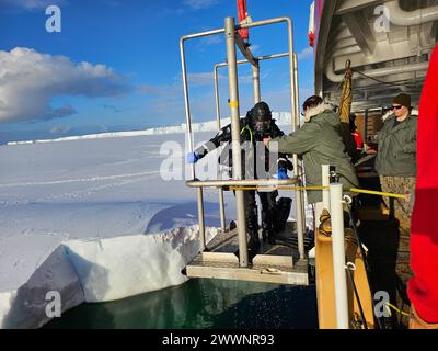 Le maître de 2e classe de la Garde côtière américaine Corey Smith, le chef principal de la Garde côtière américaine Jeff Esser, plongeurs, sont levés de l'eau sur le Polar Star de la Garde côtière américaine (WAGB 10) et assistés par le maître de 2e classe de la marine américaine James Moore, et le Petty Officer 1st Class Kevin Countie, plongeurs, après l'opération de plongée la plus méridionale dans la baie des baleines, Antarctique, le 3 février 2024. Le soutien de l'armée américaine à la recherche antarctique américaine a commencé en 1955. Le Commandement Indo-Pacifique des États-Unis continue de diriger l'équipe conjointe Force opérationnelle-Forces de soutien Antarctique en fournissant un soutien logistique à l'ONU Banque D'Images