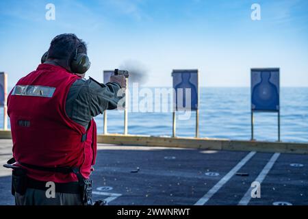 Cmdt. Derek Cameron, de préparé Petersburg, Floride, officier de frappe, se qualifie sur le pistolet M-18 à bord du porte-avions de classe Nimitz USS George Washington (CVN 73) alors qu'il est en route dans l'océan Atlantique, le 26 février 2024. George Washington mène une formation sur mesure sur la disponibilité et le problème d'évaluation finale des navires (TSTA/FEP). TSTA/FEP prépare le navire et l'équipage à une intégration complète dans un groupe de frappe de porte-avions à travers un large éventail d'opérations critiques. Marine Banque D'Images