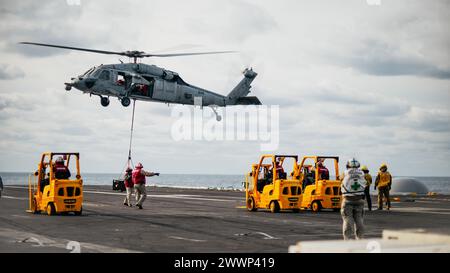 Un hélicoptère MH-60S Seahawk attaché au Helicopter Sea combat Squadron (HSC) 5 dépose des munitions sur le pont d'envol du porte-avions de classe Nimitz USS George Washington (CVN 73) dans l'océan Atlantique, le 18 février. 2024. George Washington mène actuellement des travaux sur mesure sur la disponibilité et l'évaluation finale des navires (TSTA/FEP). TSTA prépare le navire et l'équipage à une intégration complète dans un groupe de frappe de porte-avions à travers un large éventail d'opérations critiques. Marine Banque D'Images