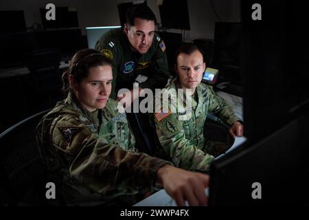 De gauche à droite, le Major Jerra Brown de l'US Space Force, directeur du développement des forces du National Space Defense Center, de l'US Navy Ltd.Matthew Dring, planificateur spatial de la NSDC, et le Major Mitchell Daugherty de l'armée américaine, chef des opérations techniques spéciales du NSDC et chef des opérations de combat, regardent un écran d'ordinateur pour soutenir Keen Edge 24 à la base spatiale Schriever, Colo, 8 février 2024. Les membres du NSDC ont soutenu KE24 à la fois chez eux et à Hawaï. KE24 est conçu pour accroître la capacité opérationnelle interarmées intégrée, affiner les procédures de commandement et de contrôle et améliorer l'interopérabilité entre les membres du cou participants Banque D'Images