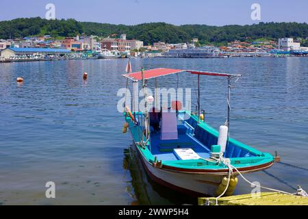 Comté de Goseong, Corée du Sud - 30 juillet 2019 : un petit bateau est amarré aux paisibles quais de Geojin, flottant sur des eaux calmes et claires. À travers les eaux Banque D'Images