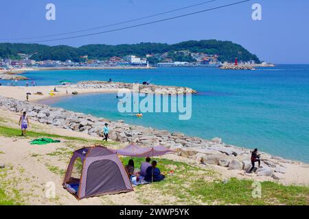 Comté de Goseong, Corée du Sud - 30 juillet 2019 : à l'extrémité nord de Geojin Village Beach, des rochers entourent le bord de l'eau avec un petit brise-lames de sable dans le Banque D'Images