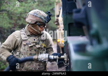 Maguel Squires, un spécialiste de l'approvisionnement en pétrole affecté au quartier général et à la Compagnie du quartier général, bataillon des troupes de soutien de la 3e division brigade de soutien de la 3e division d'infanterie, alimente un véhicule tactique moyen léger lors d'un exercice de tir réel de convoi à Swietoszow, Pologne, le 12 février 2024. Le 3e DSB teste les soldats et les équipes avec la défense individuelle et collective des unités et des exercices de tir réel de convoi pour assurer la préparation à la protection de la logistique critique et des systèmes de commandement de mission sur n'importe quel champ de bataille. Armée Banque D'Images