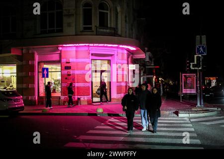 Odessa, Ukraine. 22 mars 2024. Les gens marchent dans la lumière de la fenêtre d'un bar alimenté par un générateur sur la rue Ekaterinskaya. Une attaque massive à la roquette sur l'Ukraine a eu lieu dans la matinée du 22 mars 2024. Kharkiv, Zaporizhzhia, Kryvyi Rih, Khmelnytskyi, oblast de Poltava, oblast de Vinnytsia, oblast de Lviv, oblast d'Ivano-Frankivsk, oblast de Mykolaiv, oblast d'Odessa, L'oblast de Sumy et d'autres régions du pays ont été soumis à des tirs de roquettes par l'armée russe. La centrale hydroélectrique du Dniepr a été mise hors service (huit missiles ont touché ; un trolleybus transportant des civils voyageant le long du barrage l'a été Banque D'Images