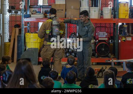 Le Cpl Benjamin Ambriz, à gauche, et le Cpl David Juarez, tous deux pompiers avec Aircraft Rescue and Firefighter, quartier général et quartier général de l'escadron de la Marine corps Air Station (MCAS) Yuma, Arizona, montrent des élèves de l'équipement de lutte contre les incendies de la Gowan Science Academy lors d'une visite scolaire à l'installation, le 15 février 2024. MCAS Yuma offre aux écoles locales la possibilité de visiter la base pour éduquer les élèves sur les carrières militaires et les modes de vie. La ville natale d’Ambriz est Bakersfield, en Californie. La ville natale de Juarez est Los Angeles, en Californie. Corps des Marines Banque D'Images