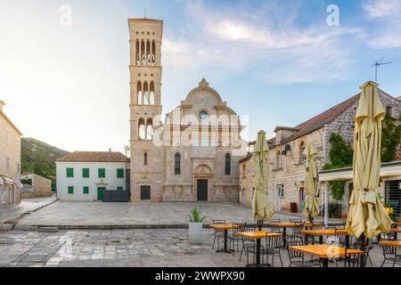 Place principale de Pjaca dans la vieille ville médiévale de Hvar avec cathédrale de équipés Stephen, restaurant en plein air et café de promenade latérale avec personne au lever du soleil, Dalmatie Banque D'Images