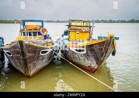 Bateaux de pêche traditionnels amarrés sur la rivière Thu bon dans la ville de Hoi an, Vietnam Banque D'Images