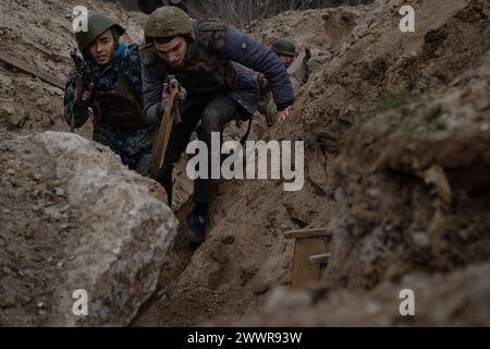 15 mars 2024, Kiev, Ukraine : des stagiaires sont vus dans une formation simulant une mission d'évacuation dans la tranchée organisée par la troisième brigade d'assaut séparée dans la région de Kiev. L'Ukraine est confrontée à une pénurie de munitions et de personnel militaire. En plus d’une loi de mobilisation plus sévère en cours, certaines brigades du pays ont choisi une approche plus encourageante pour recruter des personnes sans expérience militaire préalable pour rejoindre l’armée. La troisième brigade d'assaut offre un cours de formation gratuit de 7 jours pour permettre aux participants d'avoir un avant-goût de la formation militaire, leur permettant de trouver t Banque D'Images