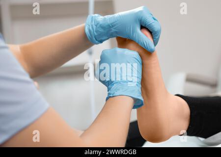 Podiatre faisant massage thérapeutique des pieds au salon de beauté. Banque D'Images