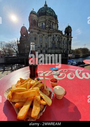 Un Coca Cola et des frites allemandes avec vue sur la célèbre cathédrale de Berlin à Berlin, en Allemagne Banque D'Images