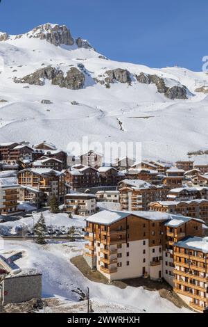 Les rochers de l'aiguille percée dominent la piste de ski et les chalets bleuets dans le quartier des Almes à Tignes, une station de ski de haute altitude dans les Alpes françaises. Banque D'Images