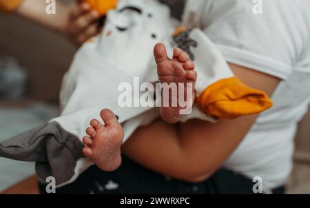 Un homme berce doucement un bébé dans ses bras, mettant en valeur un moment tendre de paternité. Banque D'Images