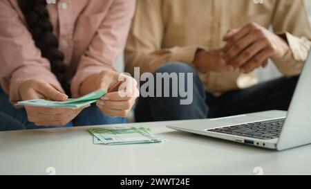 Méconnaissable femme homme comptant l'euro distribuer de l'argent en espèces salaire finances planification budget familial recadré tir les mains féminines comptent les billets de banque sur la table Banque D'Images
