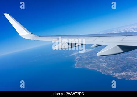 Prise de vue aérienne panoramique capturant l'aile de l'avion planant au-dessus du magnifique paysage côtier du Portugal. Banque D'Images