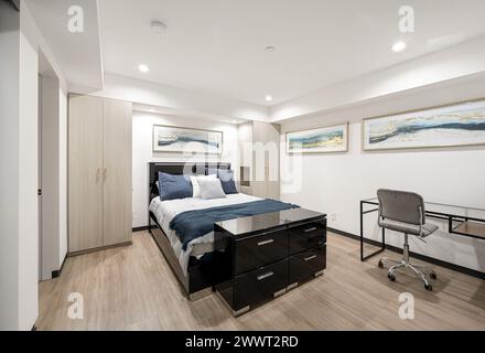 Une chambre au design moderne avec une literie chic bleue et blanche Banque D'Images