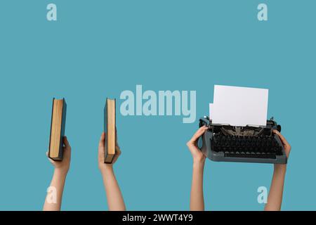 Femmes avec machine à écrire vintage et livres sur fond bleu Banque D'Images