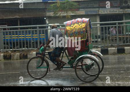 Dhaka, Bangladesh. 26 mars 2024. Un tire-pousse transporte des passagers sous la pluie à Dhaka. (Crédit image : © MD Mehedi Hasan/ZUMA Press Wire) USAGE ÉDITORIAL SEULEMENT! Non destiné à UN USAGE commercial ! Banque D'Images