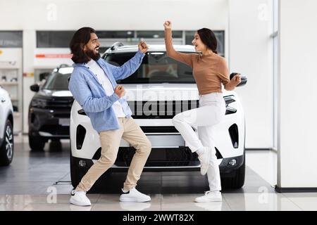 Deux personnes célèbrent l'achat d'une nouvelle voiture Banque D'Images