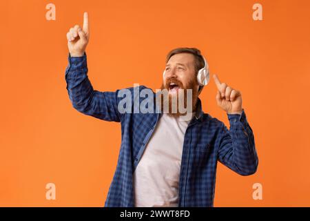 Portrait de drôle de gars chantant écouter de la musique dans des écouteurs, studio Banque D'Images