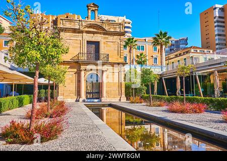 Le petit parc avec fontaine en face du grès baroque historique la Capilla del Puerto de Malaga (Chapelle du Port de Malaga), la jetée Muelle Uno, Espagne Banque D'Images