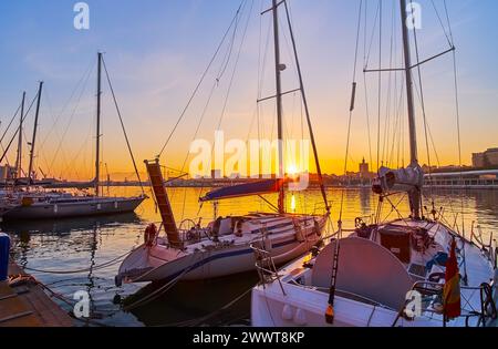 Regardez le magnifique coucher de soleil à travers les yachts à voile dans le port de Malaga, en Espagne Banque D'Images