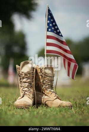 Vieilles bottes de combat militaires contre drapeau américain en arrière-plan. Memorial Day ou Veterans Day, concept de sacrifice. Banque D'Images