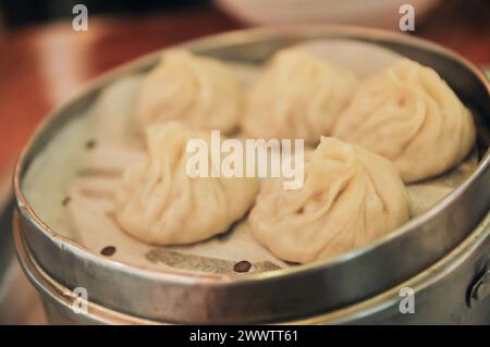 Gros plan de Xiao long Tang Bao chinois cuit à la vapeur, également connu sous le nom de boulettes de soupe parce que le remplissage à l'intérieur est en fait soupe liquide servi str en bois brun Banque D'Images
