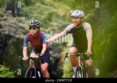 jeunes cyclistes de couple asiatique faisant du vélo sur la route rurale Banque D'Images