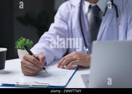 le médecin tient un stylo et écrit des notes sur les examens, les antécédents médicaux des patients. prescription médicale Banque D'Images
