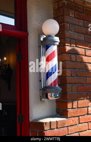 Un poteau de barbier à l'extérieur d'un salon de coiffure Banque D'Images