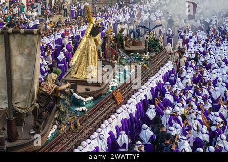 Antigua, Guatemala. 24 mars 2024. Les pénitents catholiques portent le flotteur processionnel massif alors qu'il se déplace autour de la place centrale pendant la procession de 20 heures du dimanche des Rameaux la Reseña, le 24 mars 2024 à Antigua, au Guatemala. Les processions opulentes, les algèbres détaillées et les traditions séculaires attirent plus d'un million de personnes dans l'ancienne capitale. Crédit : Richard Ellis/Richard Ellis/Alamy Live News Banque D'Images