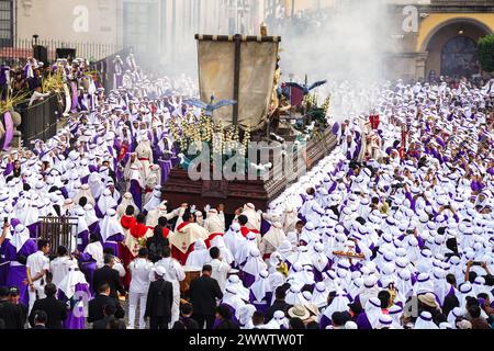 Antigua, Guatemala. 24 mars 2024. Les pénitents catholiques portent le flotteur processionnel massif alors qu'il se déplace autour de la place centrale pendant la procession de 20 heures du dimanche des Rameaux la Reseña, le 24 mars 2024 à Antigua, au Guatemala. Les processions opulentes, les algèbres détaillées et les traditions séculaires attirent plus d'un million de personnes dans l'ancienne capitale. Crédit : Richard Ellis/Richard Ellis/Alamy Live News Banque D'Images