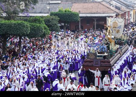 Antigua, Guatemala. 24 mars 2024. Les pénitents catholiques entourent le massif flotteur processionnel alors qu'il se déplace sur la place centrale pendant la procession de 20 heures du dimanche des Rameaux la Reseña marquant le début de la semaine Sainte, le 24 mars 2024 à Antigua, au Guatemala. Les processions opulentes, les algèbres détaillées et les traditions séculaires attirent plus d'un million de personnes dans l'ancienne capitale. Crédit : Richard Ellis/Richard Ellis/Alamy Live News Banque D'Images