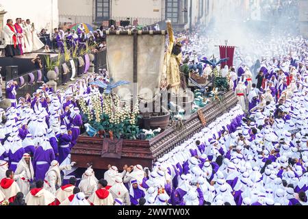 Antigua, Guatemala. 24 mars 2024. Les pénitents catholiques portent le flotteur processionnel massif alors qu'il se déplace autour de la place centrale pendant la procession de 20 heures du dimanche des Rameaux la Reseña, le 24 mars 2024 à Antigua, au Guatemala. Les processions opulentes, les algèbres détaillées et les traditions séculaires attirent plus d'un million de personnes dans l'ancienne capitale. Crédit : Richard Ellis/Richard Ellis/Alamy Live News Banque D'Images