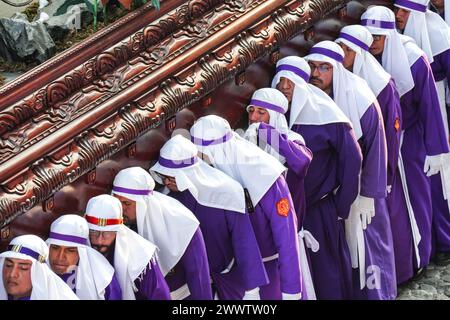 Antigua, Guatemala. 24 mars 2024. Un pénitent catholique essuie les larmes alors qu'il aide à porter le flotteur processionnel massif alors qu'il se déplace sur la place centrale pendant la procession de 20 heures du dimanche des Rameaux la Reseña, le 24 mars 2024 à Antigua, Guatemala. Les processions opulentes, les algèbres détaillées et les traditions séculaires attirent plus d'un million de personnes dans l'ancienne capitale. Crédit : Richard Ellis/Richard Ellis/Alamy Live News Banque D'Images