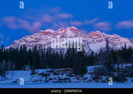 Lever du soleil sur la crête est du mont Cascade en hiver vu depuis le lac Two Jack dans le parc national Banff, Alberta, Canada. Banque D'Images