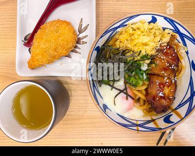 Udon, boeuf Udon ou Niku Udon sont des nouilles Udon dans la soupe chaude, avec des tranches de ​​beef, nori, et un œuf de tamago à moitié cuit servi dans un bol Banque D'Images