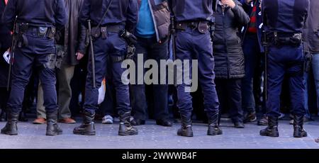 Un groupe de policiers devant quelques manifestants Banque D'Images